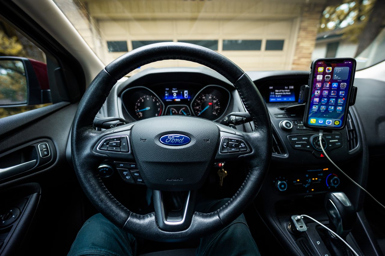 hero-01 Interior view of a Ford car featuring a steering wheel, dashboard, and mobile device mount.